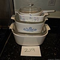 Stacked CorningWare bakeware dishes showing the different floral patterns and glass lids.