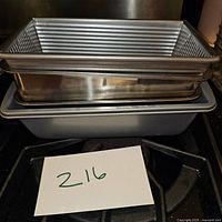 Stack of metal bread pans showing ribbed and plain rectangular types for bread baking