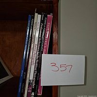Photo showing the spines of seven portrait photography books arranged vertically in a wooden shelf.