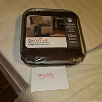 Packaged brown Quick Cover waterproof furniture protector for recliner chair with product label showing features.