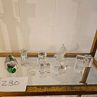 Photo showing entire lot of 7 glass and crystal figurines including paperweight, animal shapes, and geometric blocks.