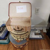 Top view showing the interior and lid of the square floral striped hat box, open and empty.