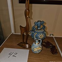 Photo showing the full lot with tall wooden giraffe sculpture, two decorative vases, and wooden fish figurine on a table.