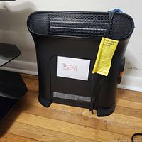 Back side view of Honeywell ceramic heater with black mesh grille and power cord taped to side.