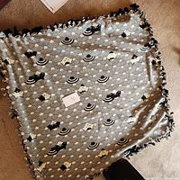 Full view of kitten patterned throw blanket laid out flat, showing the pattern and knotted fringe edges