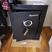 Front view of safe with door ajar showing keypad and handle