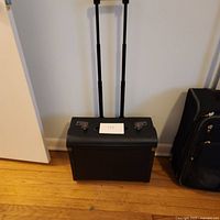 Full view of the black leather lawyer's case standing upright with telescoping handle extended.