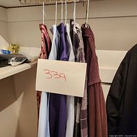 Lot of six men's shirts on hangers, various colors and patterns including solid and checked shirts