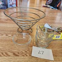 Metal display bowl, four small glass bowls, and a Veggetti spiralizer box on wooden floor.
