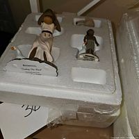 Four nativity figurines shown in original white styrofoam packaging, one wrapped in plastic.