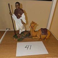 Photo showing both shepherd and camel figurines on a shelf with a paper marked '41' in front.