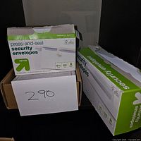 Two different boxes of Target Up & Up press-and-seal security envelopes in their packaging with quantity labels visible. One box contains 95 envelopes, the other 125 envelopes.