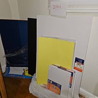 Several poster boards stacked upright including white, black, yellow colors, and foam boards