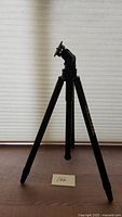 Front view of the black Titall tripod showing three legs and tilting head.