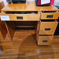 Image of the front of the wood desk showing four drawers and wood grain