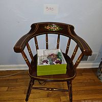 Wooden chair with floral details and boxed floral arrangement on the seat