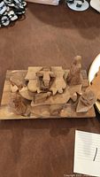Wooden nativity puzzle pieces assembled on base showing Mary, Joseph, Baby Jesus, and three animals.