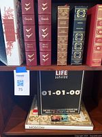 Books on shelf including Leather-bound Chesapeake Vol 1 & 2, Doctor Zhivago, Exodus, and Adolf Hitler Volumes