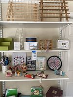 Wide view of shelves displaying craft items including organizers, fabric pin cushions, clock, signs, and eyeglasses holder.