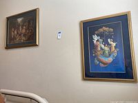 View of two framed art pieces on a wall, focusing on the featured large fantasy fairy tale print on the right with a golden wooden frame and blue matting.