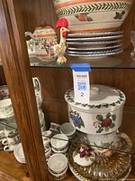 Assorted ceramic pieces and glass platter on shelf