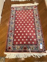 Top view of one 3x5 feet rectangular rug showing floral center and detailed border with fringe.