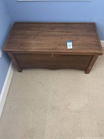 Closed wooden chest with brown finish, rectangular shape, and minor surface wear.