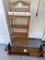 Full view of wooden utility rack with four shelves and a separate, longer wall shelf with cubby and drawer compartments.
