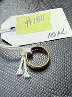 Plain yellow gold ring band with attached tag marked #80 and 10K.