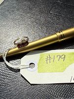 Ring side view on gold pen showing four red stones and split shank band
