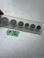 Set of seven 1969 Canadian coins in clear plastic holder with a small note labeled #33 1969.
