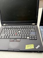 Photo showing Lenovo ThinkPad T420 laptop with worn keyboard and some missing keys.