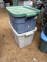 Photo showing two stacked Roughneck brand plastic storage totes with lids, the top tote blue with a green lid, the bottom gray with a gray lid, in good used condition.