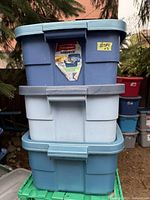 Three stacked plastic storage totes showing the top tote with original Rubbermaid Roughneck label.