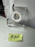 Clear acrylic display case containing a 50 pence coin with colored image of Peter Rabbit.