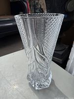 Crystal vase with detailed cut glass design, shot from a side angle showing its full shape and intricate patterns.