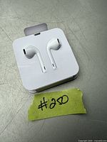 Photo of Apple EarPods in original plastic tray packaging, showing the earbuds and part of the cable.