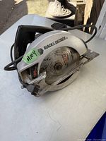 Photo showing a silver and black Black & Decker circular saw with 180mm blade, corded and in good used condition, labeled #04