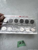 Two plastic holders containing Canada 125 1867-1992 commemorative quarter coins. Each coin represents a different province or territory.