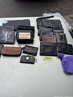 Overview of assorted wallets laid out on a table including black, brown, and purple ones.