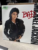 Photo of the Michael Jackson 'Bad' album cover showing Michael Jackson in a black leather jacket and the word 'BAD' in red.