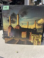 Front cover of Pink Floyd Animals album showing Battersea Power Station with flying pig and wear on edges.