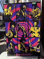 Poster shown outdoors displaying the entire artwork with vivid colors and some reflections.