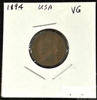 Front side of the 1894 US Indian Head 1 Cent coin mounted in protective cardboard holder showing '1894 USA VG' written on it.