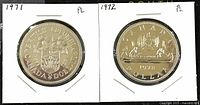 Front side of 1971 and 1972 Canadian one dollar coins in protective holders, showing the reverse sides of both coins.