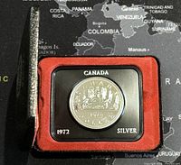 1972 Canadian silver dollar coin in an open protective case with red lining, coin clearly visible with date and silver content on the case edges.