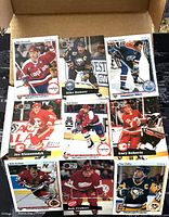 Close-up photo of assorted NHL hockey player trading cards with visible player names and teams from the 1980s and 1990s.