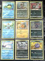 Photo of nine Pokémon cards laid out showing front art and details including Qwilfish, Krokorok, Poochyena, Chewtle, Pikachu, Zorua, Snom, Absol, and Koffing.