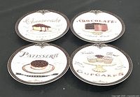 Top view of four dessert plates arranged in a square, showing cheesecake, chocolate cake, raspberry tart, and cupcake illustrations.