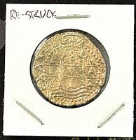 Front side of the re-struck Spanish doubloon showing two castles and wave design with raised lettering around the edges.